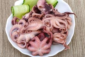 pulpo marinado en el plato y fondo de madera foto