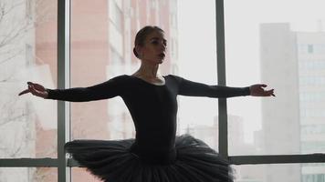 ballerina on a background of the city a beautifully moving dance. In a black tutu and Pointe shoes. The image of the black Swan from the ballet. Slow motion video