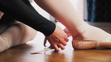 Kaukasisch jong meisje ballerina in zwart tutu jurk pointe schoenen Aan haar voeten. de kunst van ballet. klassiek dans. voorbereiding voor opleiding. langzaam beweging. detailopname video