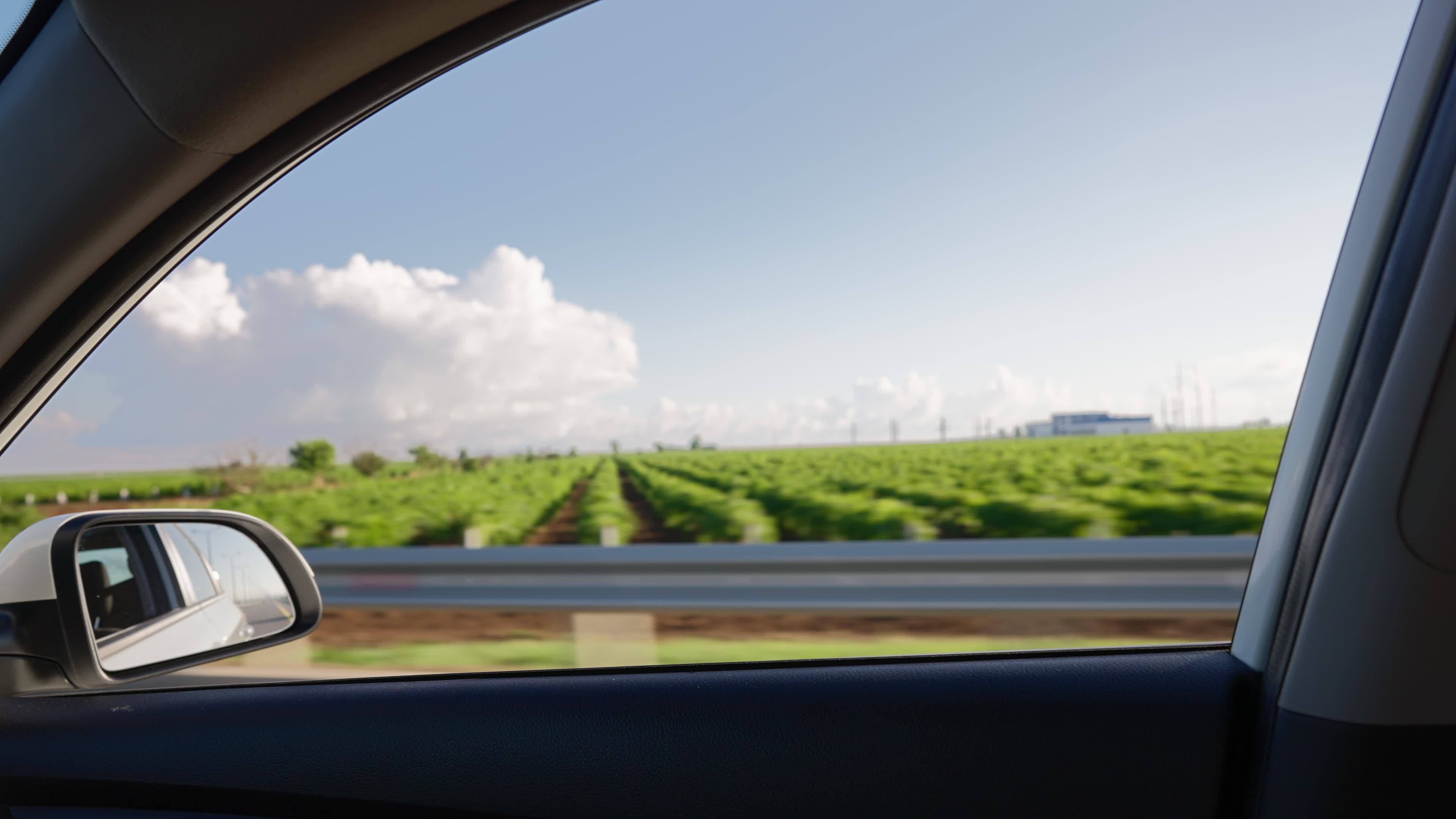 View From The Side Window Of A Car Driving Fast Along The Highway view-from-the-side-window-of-a-car-driving-fast-along-the-highway