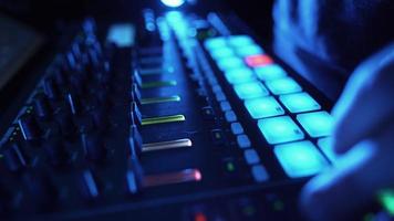 Professional DJ Plays a Beat Sampler with Color Drum Pads and Samples in Studio Environment. Beatmaker Plays edm Tracks on Party in a Nightclub. Electronic Musical Instrument. Unrecognizable person