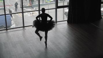 Girl ballerina in a black tutu in the dance hall. Practice ballet. Slow motion. Top view video