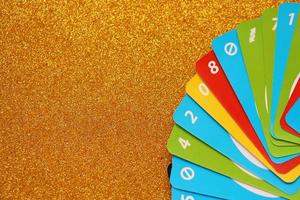 TERNOPIL, UKRAINE - MAY 15, 2022 Many colorful UNO game cards on golden background. UNO is an American shedding-type card game that is played with a specially printed deck photo