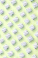 Colorful marshmallow laid out on lime paper background. pastel creative textured pattern photo