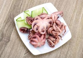 pulpo marinado en el plato y fondo de madera foto