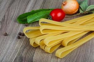 Fettuccine on wooden background photo