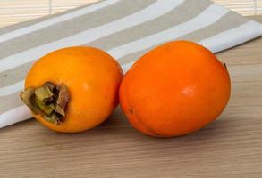 Persimmon on wood photo