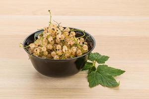 White currant in a bowl on wooden background photo