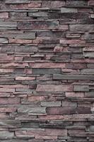 Texture of a stone wall from long and rough stones of different sizes and tones photo