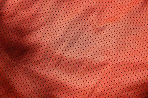 Sport clothing fabric texture background, top view of red cloth textile surface photo