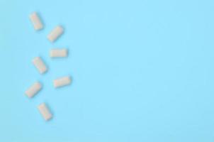 A few chewing gums lie on texture background of fashion pastel blue color paper photo