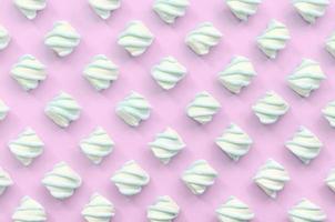 Colorful marshmallow laid out on pink paper background photo