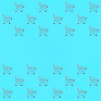 Shopping addiction, shopping lover or shopaholic concept. Many small empty shopping carts perform a pattern on a pastel colored paper background. Flat lay composition, top view photo