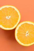 Top view of a several orange fruit slices on bright background in orange color. A saturated citrus texture image photo