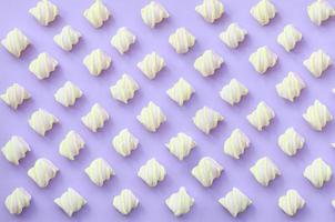 Colorful marshmallow laid out on violet paper background. pastel creative textured pattern. minimal photo