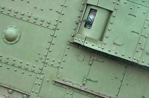 Texture of tank side wall, made of metal and reinforced with a multitude of bolts and rivets photo