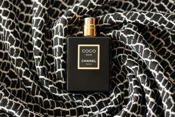 TERNOPIL, UKRAINE - SEPTEMBER 2, 2022 Coco Noir Chanel Paris worldwide  famous french perfume black bottle on shiny glitter background in purple  colors 13586996 Stock Photo at Vecteezy