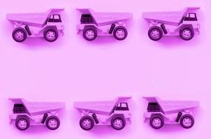 Many small purple toy trucks on texture background of fashion pastel purple color paper photo