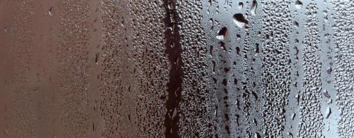 Texture of a drop of rain on a glass wet transparent background. Toned in grey color photo