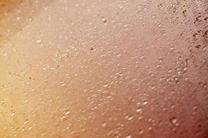 Background image of rain drops on a glass window. Macro photo with shallow depth of field. Toned picture