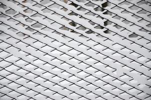 Close-up metal mesh covered with a thick layer of snow in the cells photo
