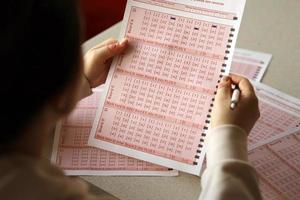 Filling out a lottery ticket. A young woman plays the lottery and dreams of winning the jackpot photo