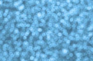 Blurred blue decorative sequins. Background image with shiny bokeh lights from small elements photo