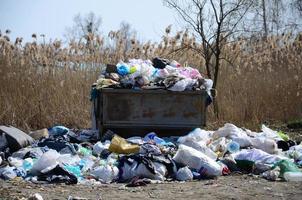 The garbage can is packed with garbage and waste. Untimely removal of garbage in populated areas photo