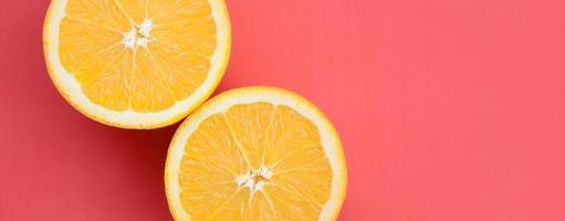 Top view of a several orange fruit slices on bright background in red color. A saturated citrus texture image photo