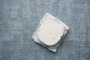 top view of fresh goat cheese and grape fruit on wooden background. photo