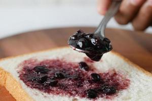 blue berry jam on bread on table, photo