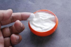 man applying beauty cream onto skin photo