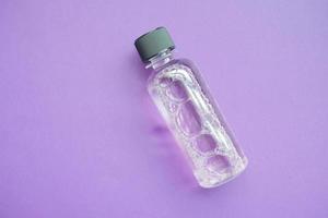mouthwash liquid in a container on purple background photo