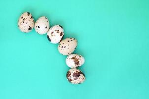 Quail eggs on a light green surface, top view, empty place for text, recipe photo