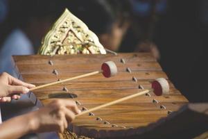 xilófono cultura asiática instrumento de música clásica gamelan, primer plano manos músico golpeando el instrumento de xilófono alto de madera tailandés. foto