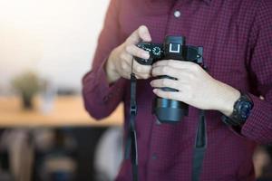 Man holding camera Wearing a red and black plaid. photo