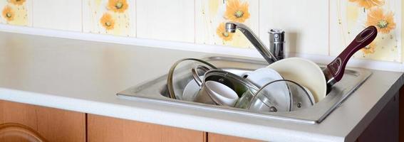 Dirty dishes and unwashed kitchen appliances filled the kitchen sink photo