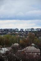 un paisaje rural con muchas casas privadas y árboles verdes. panorama suburbano en una tarde nublada. un lugar lejos de la ciudad foto