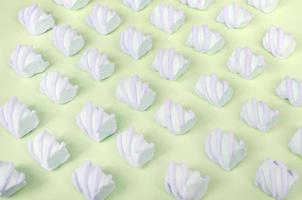 Colorful marshmallow laid out on lime paper background. pastel creative textured pattern photo