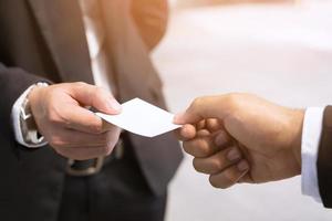 hombre de negocios en la mano sostenga mostrar tarjetas de visita tarjeta blanca en blanco maqueta presentación dar para conectar contactos comerciales. concepto de marca comercial. foto
