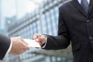 business man in hand hold show business cards blank white card mock up filing give to connect business contacts. Business branding concept. photo