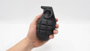 mano de hombre y bomba militar modelo de juguete de plástico. foto