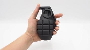 Man hand and military bomb plastic model toy. photo