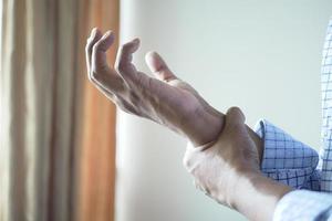 man suffering pain in hand close up photo