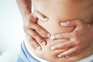 young man suffering stomach pain close up. photo