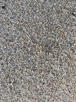 This is a picture of a background of sand on the beach that has just been washed away by the waves photo