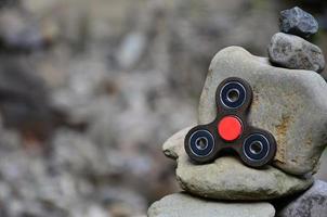 A wooden spinner lies on strange stone structures in the forest photo