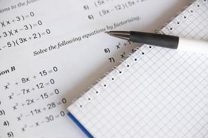 Handwriting of mathematics quadratic equation on examination, practice, quiz or test in maths class. Solving exponential equations concept. photo