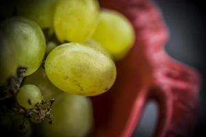 A close-up photo of white grapes in a red bowl