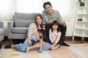retrato de familia asiática sonriendo en el sofá en casa foto